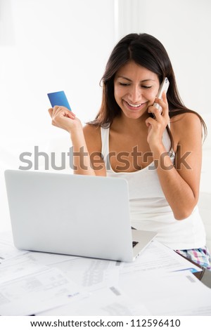 Woman talking to the bank on the phone and buying online