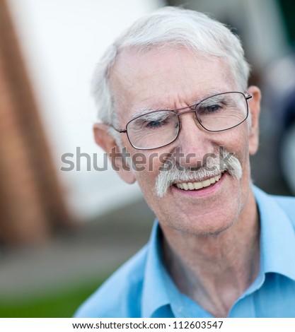 Portrait of a happy old man outside his house