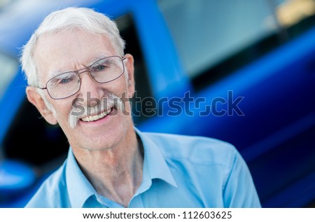 Elder man with a car looking happy and smiling