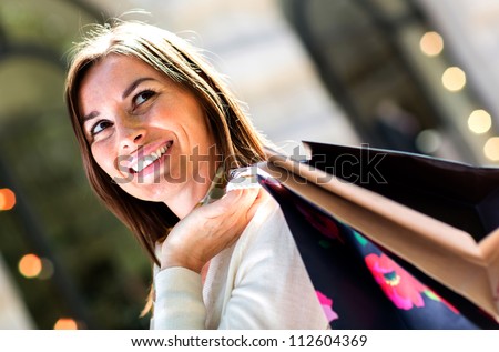 Female shopper holding shopping bags and looking happy