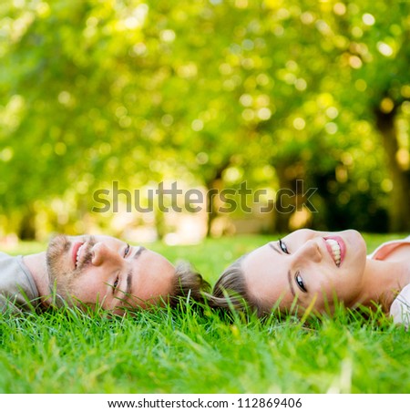Happy couple in love laying on the floor outdoors