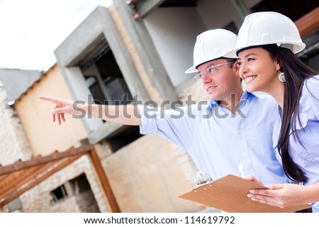 Civil engineers working in a construction site and pointing away
