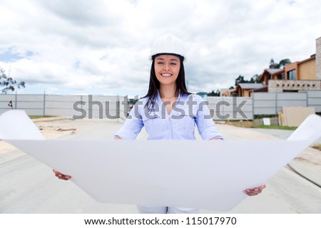 Female civil engineer looking at a house blueprints