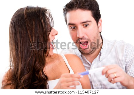 Surprised couple doing a pregnancy test - isolated over a white background