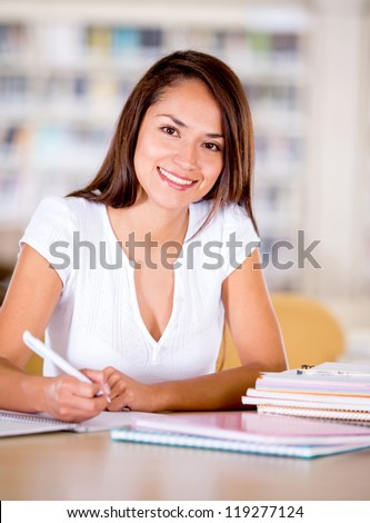 Happy university woman at the library studying