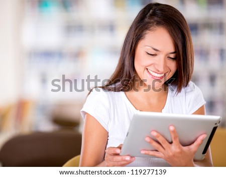 Woman reading at the library on an e-book reader