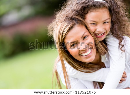 Happy mother and daughter laughing together outdoors