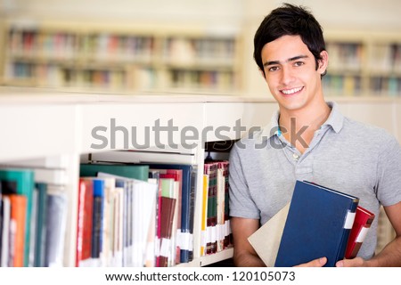 Happy Male Student Holding Books At The Library