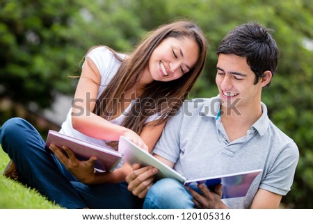 Young couple studying at the park and smiling Young couple studying at the park and smiling
