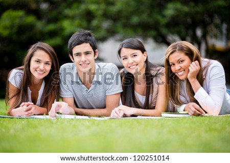 Group of students outdoors lying on the floor and smiling