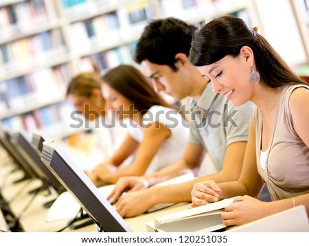 Group university ICT students using computers and smiling