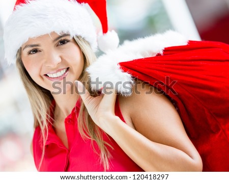 Happy female Santa carrying a gift sack and smiling
