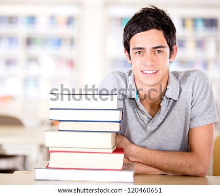 Male Student At The Library With A Pile Of Books