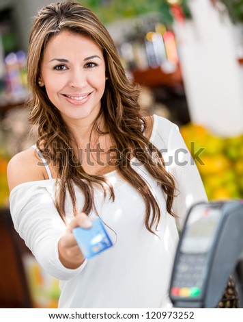 Woman at the checkout paying by credit card
