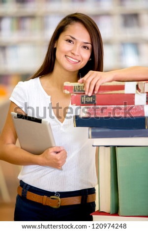 Female student at the library holding a tablet computer