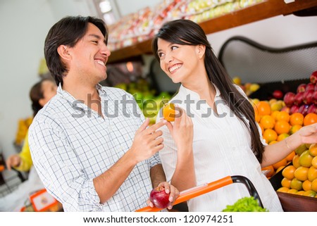 Happy couple grocery shopping at the local market
