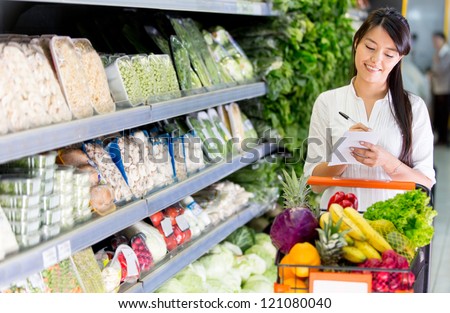 Woman with a shopping list for groceries at the market