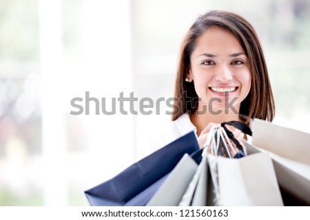 Latin woman holding shopping bags looking happy