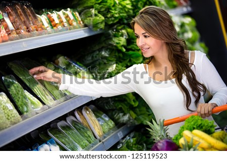 Happy woman grocery shopping at the supermarket