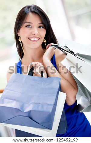 Beautiful shopping woman holding bags and looking happy