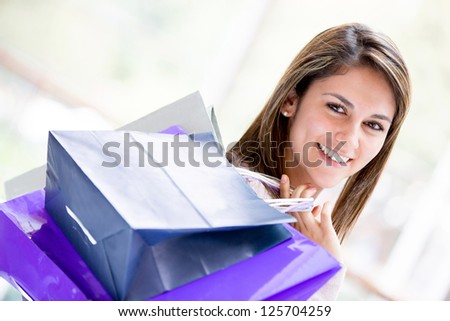 Beautiful female shopper holding shopping bags and smiling