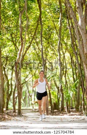 Healthy woman jogging outdoors looking very happy