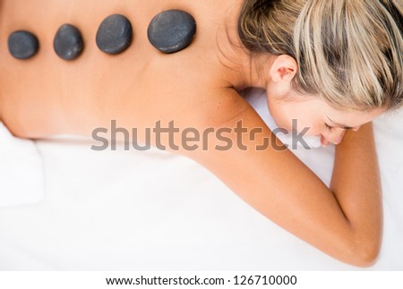 Woman getting a relaxing massage with hot stones