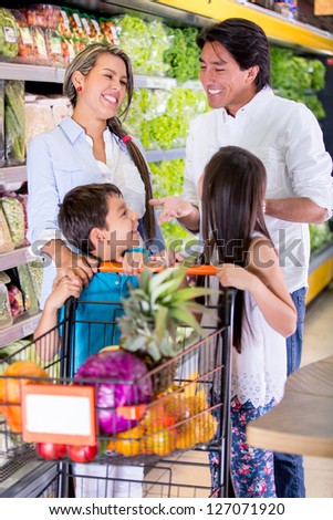 Happy family at the supermarket grocery shopping