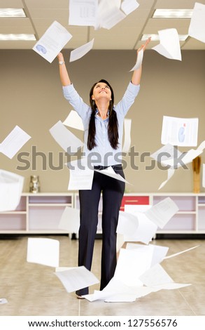 Successful businesswoman throwing papers in the air