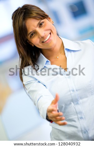 Welcoming business woman with hand extended to handshake