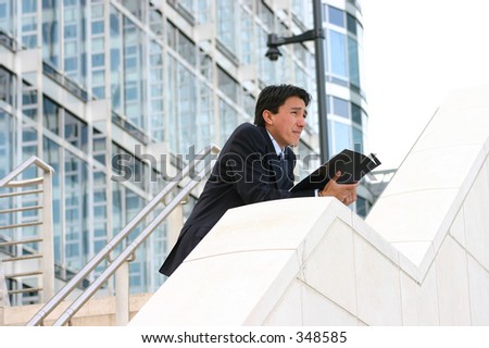 business man looking at the horizon with a magazine on his hands