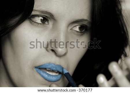 beautiful woman applying blue lipstick - enphasis on lipstick