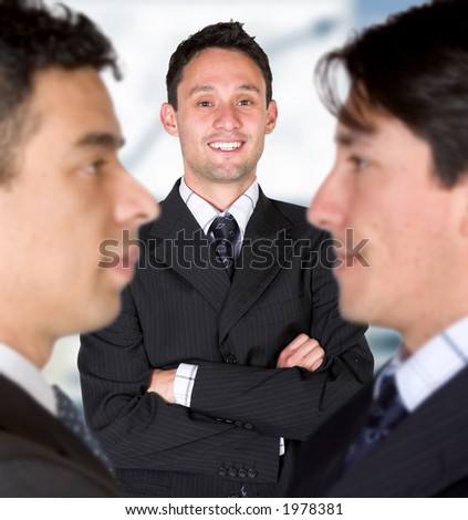 business man facing the camera with his parters either side with blurry faces