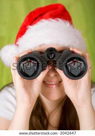 female santa searching for gifts - note the gifts on the binoculars lens reflection
