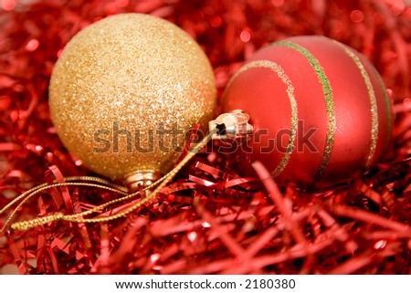 gold and red christmas balls on red metallic shreds