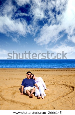 stock photo : couple in love - heart shape on the beach with a beautiful blue