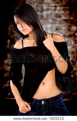 female fashion portrait over a dark background where she is pulling her blouse