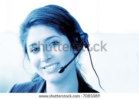 customer support center woman in an office smiling - blue tones