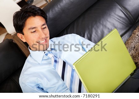 business man on a laptop computer browsing the internet at home comfortably sitting in his sofa