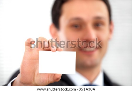 businessman showing his business card in an office smiling