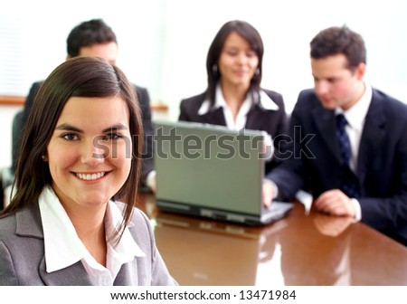 business woman in an office environment with people working behind her