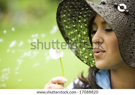 Beautiful girl blowing a flower - smiling outdoors
