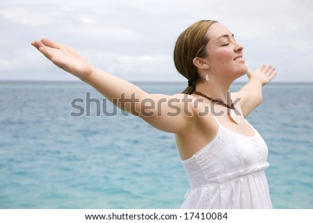 Beach freedom woman with arms open enjoying peace and tranquiity