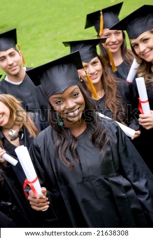group of graduation students smiling and looking happy in their gowns