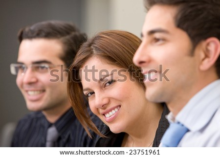Business people in an office smiling - small team