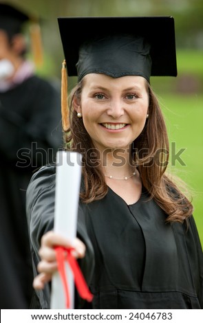 Female graduation portrait smiling and showing her diploma