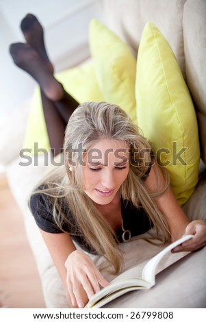 Relaxed woman lying on the couch reading
