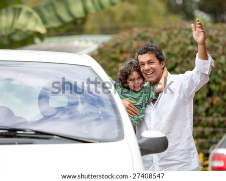 Father and son smiling with a car outdoors