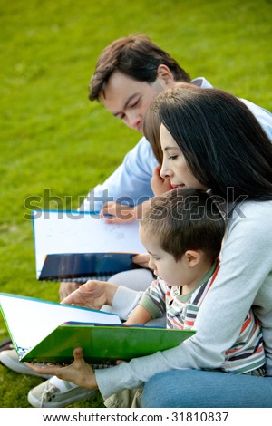Beautiful portrait of a family reading at the park