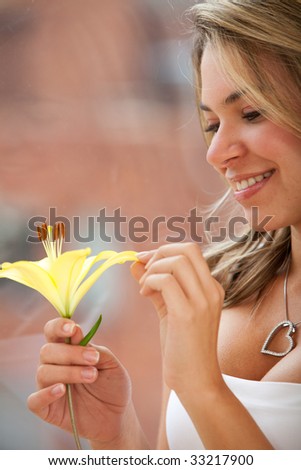 Beautiful woman staring at a flower smiling